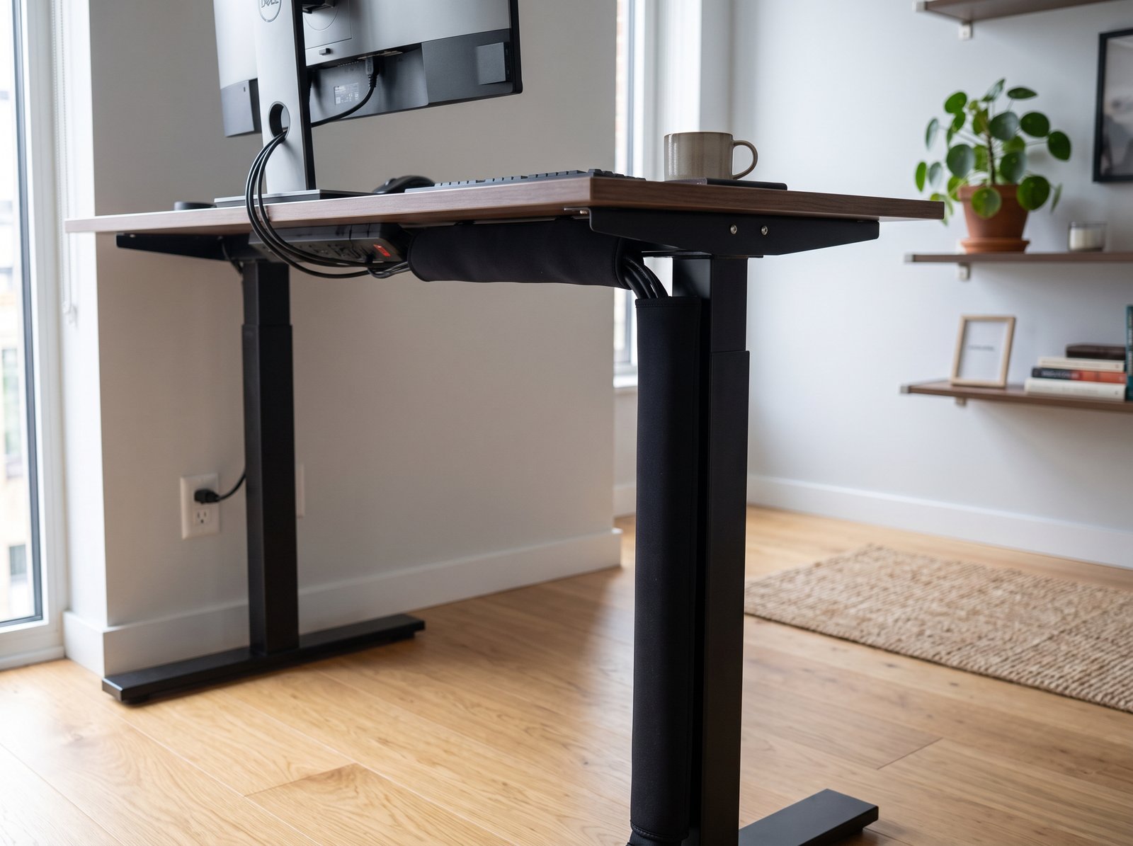 Neoprene zipper cable management sleeve bundling messy cords along a desk leg